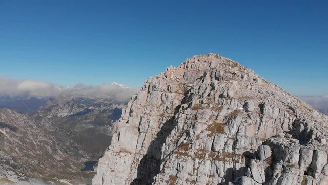 drone lift above mighty mountain peak Krn in Julian Alps, Slovenia, blue sky