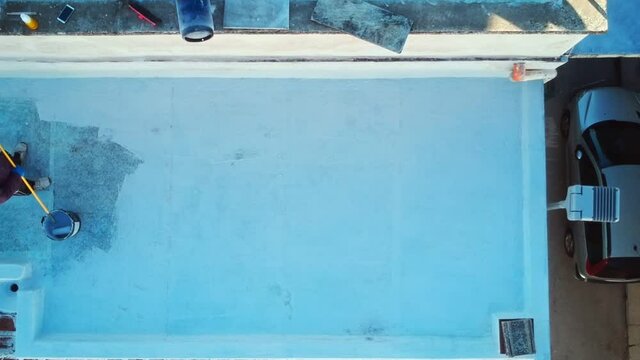 Aerial view with the drone of workers who carry out the waterproofing of a terrace with resin, making the surface pedestrian and with excellent aesthetics