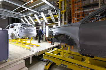 Car bodies are on assembly line. Factory for production of cars. Modern automotive industry. A car being checked before being painted in a high-tech enterprise