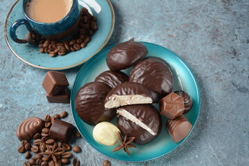Zefir (zephyr),coffee cup, beans, chocolate on kitchen table Assortment of dark, white and milk chocolate sweets.