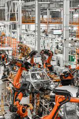 Vertical photo of automobile production line. Modern car assembly plant. Auto industry. Interior of...