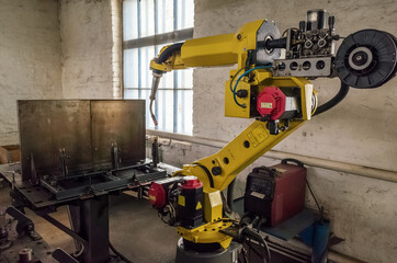 A welding robot in a production room of a mechanical plant. The picture was taken in Russia