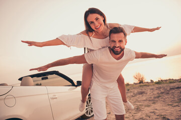 Photo portrait couple laughing together playing outside on beach near cabriolet car