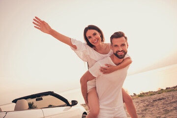 Photo of carefree funny wife husband wear casual clothes driving cabriolet piggyback enjoying sunny...