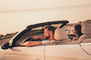Photo portrait male driver sitting with girlfriend in cabriolet car enjoying view on beach by sea