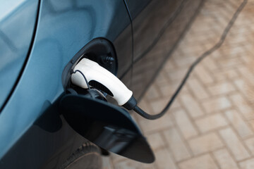 Top view close-up of plug-in electric car on charging station.
