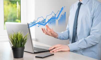 Business man holding tablet and showing holographic graphs and stock market statistics gain profits. Concept of growth planning and business strategy. Display of good economy form digital screen.