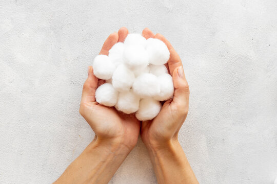 Female hands holding cotton wool balls for cleansing skin and boby care