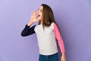 Little girl isolated on purple background shouting with mouth wide open to the side