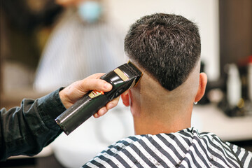 Professional barber using an electric shaver or trimmer