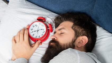 Portrait of man sleeping with alarm clock in bed, sleep time