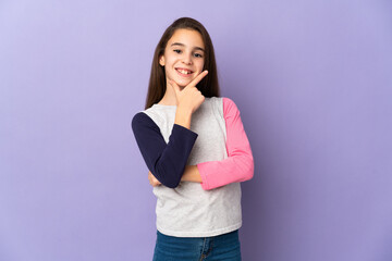 Little girl isolated on purple background happy and smiling