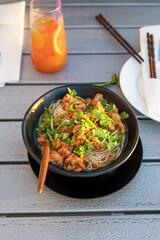 Asian soup noodles with chicken and vegetables served on a table