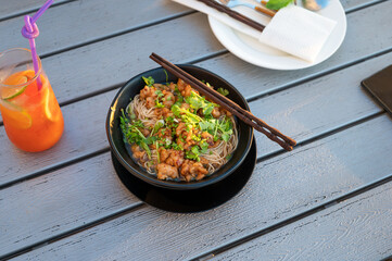Asian soup noodles with chicken and vegetables served on a table