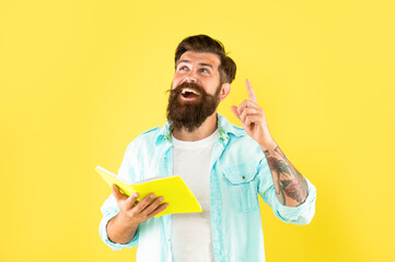 inspired with idea hipster guy reading notebook on yellow background, inspiration