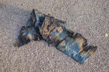 Burnt pants jeans trash lie on the road