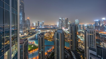 Dubai downtown with fountains and modern futuristic architecture aerial night to day timelapse