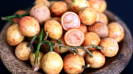 Menteng fruit or Baccaurea racemosa on wood plate. 