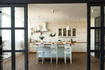 Modern dining room and kitchen interior with table and chairs, big window and wooden floor. Home decor, interior design