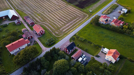 Traditional red wooden houses in Sweden in the summer. Agriculture in a Swedish village.