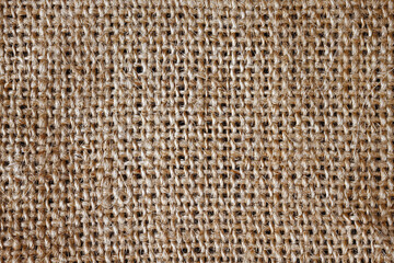 A piece of burlap fabric lies on the table. Flat lay, top view, close up, macro