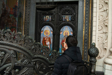 The guy looks at the frescoes of the building. Holy icon.