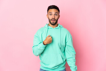 Young caucasian man isolated on pink background pointing to oneself