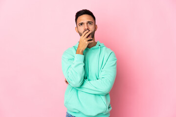 Fototapeta premium Young caucasian man isolated on pink background surprised and shocked while looking right