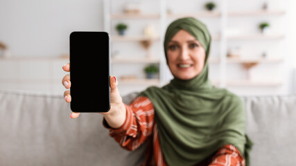 Happy Senior Muslim Woman Showing Smartphone Empty Screen Indoor, Panorama