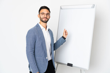 Young caucasian man isolated on white background giving a presentation on white board