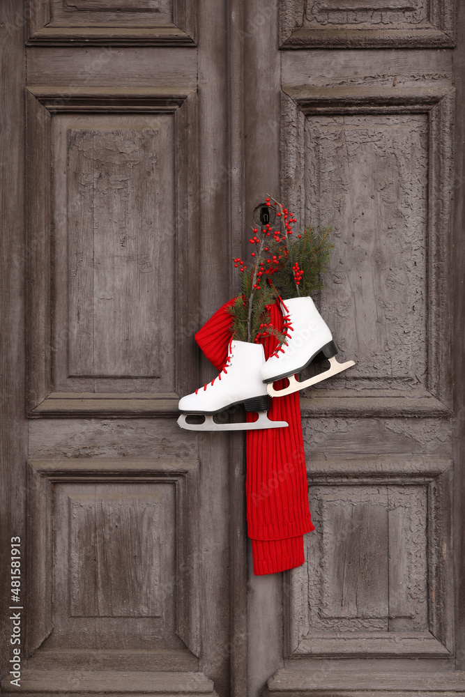 Sticker Pair of ice skates with Christmas decor hanging on old wooden door