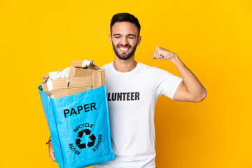 Young caucasian man holding a recycling bag full of paper to recycle isolated on white background doing strong gesture