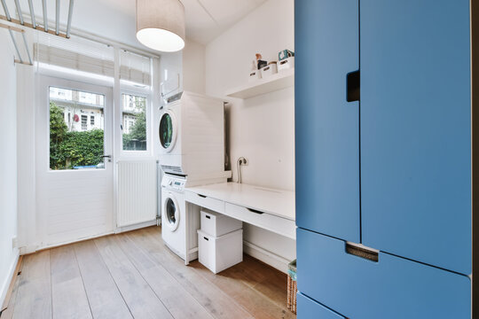 Charming Laundry Room With Washing Machine And Blue Wardrobe
