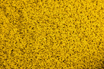 yellow rubber crumb mixed with adhesive and ready to be applied to the surface. Installation of...