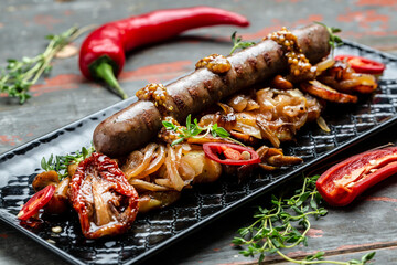Potatoes with sausages, cut into slices and fried in oil, served with chili peppers and mustard on a wooden background. Healthy fats, clean eating for weight loss