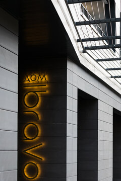 PERM, RUSSIA OCTOBER 10, 2021: A sign with the name of a residential building on the facade is Russian. The house is covered with decorative facade tiles of dark gray color.
