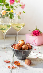 S.Valentine's Day concept. Sparkling wine in two glasses, litchi berries, roses and gift