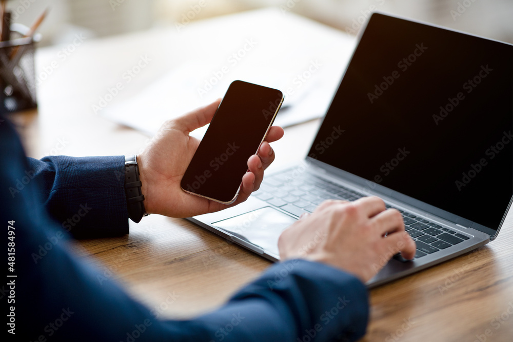 Aufkleber unrecognizable arab businessman using laptop and cellphone with mockups for website or app design, c