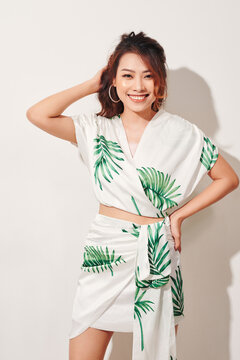 Beautiful young woman in tropical print green and white dress