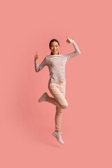 Cheerful Asian Woman Showing Thumbs Up At Camera While Jumping In Air