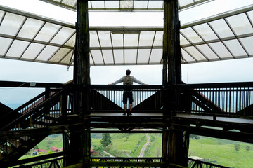 Full length view of unrecognizable man sightseeing on viewpoint in Colombian valley. Horizontal panoramic rear view of man outline traveling in Filandia. 