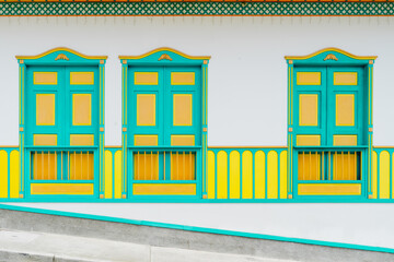 Horizontal front view of colorful decorated facade in Salento city. Panoramic view of empty yellow and green facade in traditional houses in Colombia. Travel destinations concept.