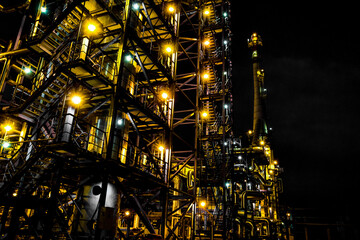 Refinery pipes and buildings at night - big factory lights