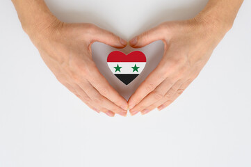 The national flag of Syria in female hands. The concept of patriotism, respect and solidarity with...