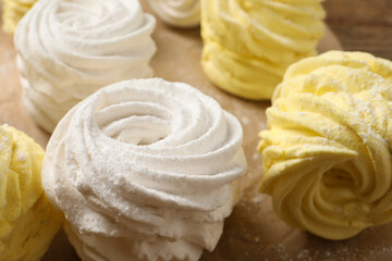 Many delicious yellow and white marshmallows on parchment paper, closeup