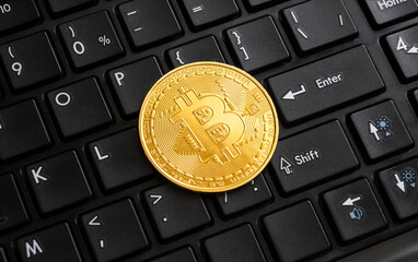 Bitcoin golden coin on black computer keyboard