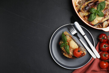 Plate of delicious eggplant lasagna served on black table, flat lay. Space for text