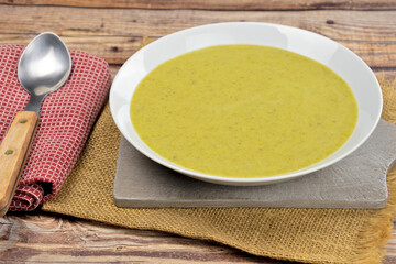soup with vegetables and spoon on wooden background