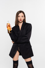 seductive woman in lace panties, black blazer and stockings posing with bottle of beer isolated on...