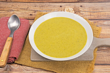 soup with vegetables and spoon on wooden background